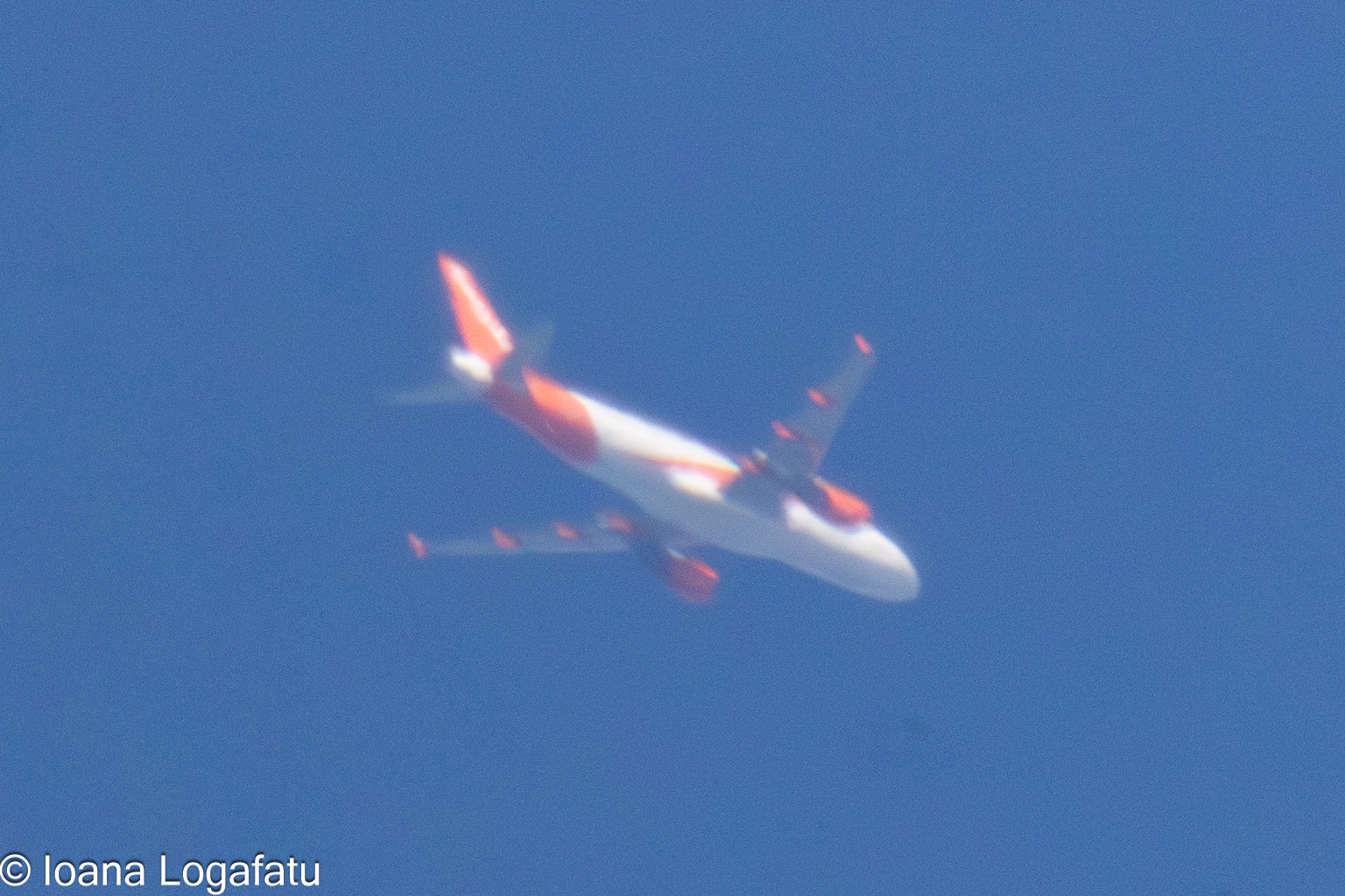Airplane soaring high in the clear blue sky